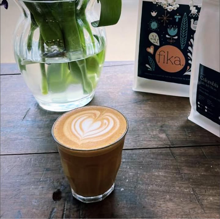 Flat white beside a bag of fika coffee beans